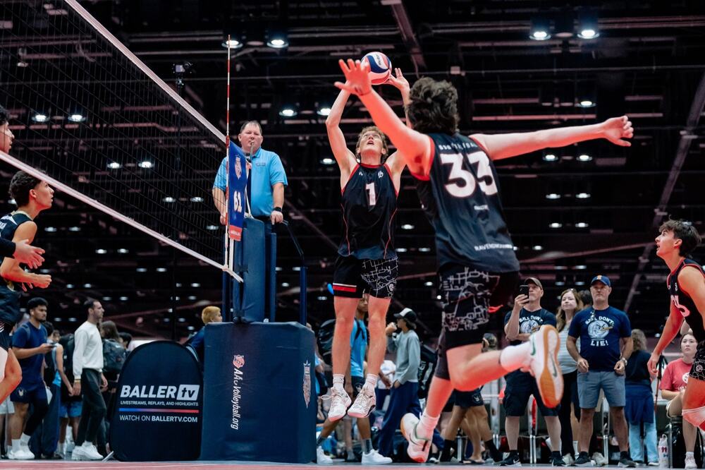 A 630 Volleyball athlete attacking at the net against a block, AAU Nationals in Orlando